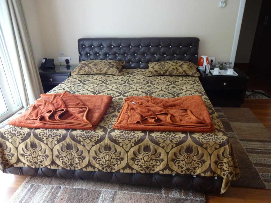 CSI Deluxe Room with double bed, bedside tables and a window